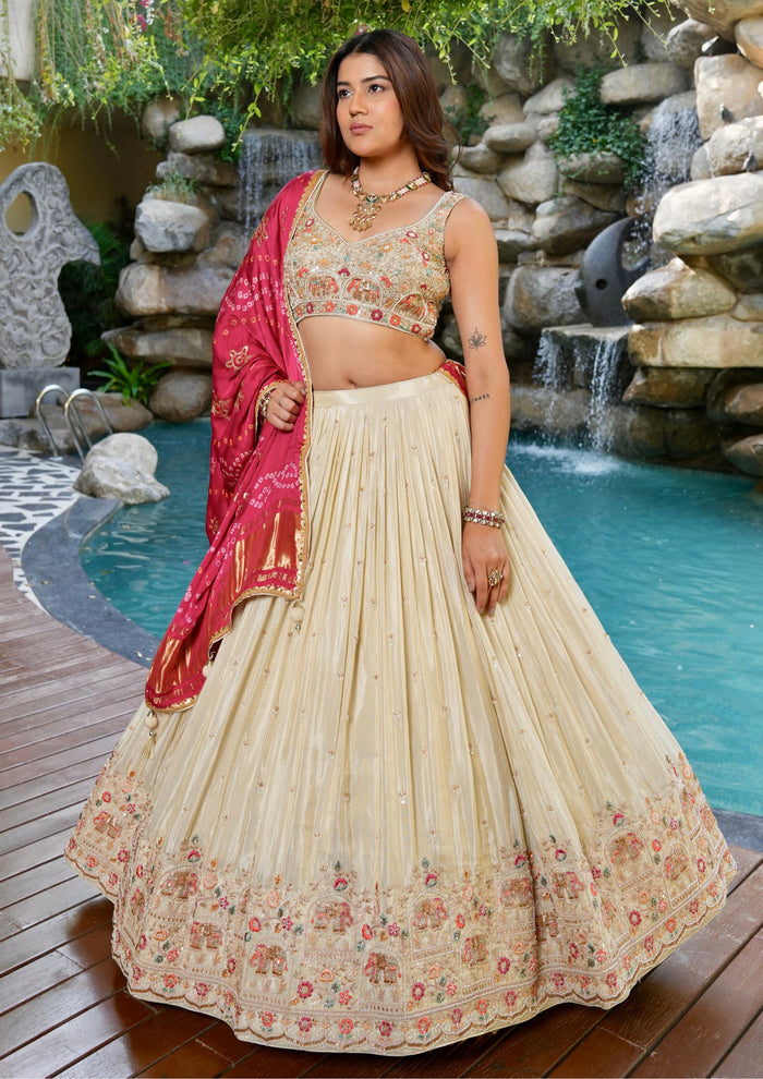 Beige designer Chaniya Choli with elephant embroidery and red dupatta